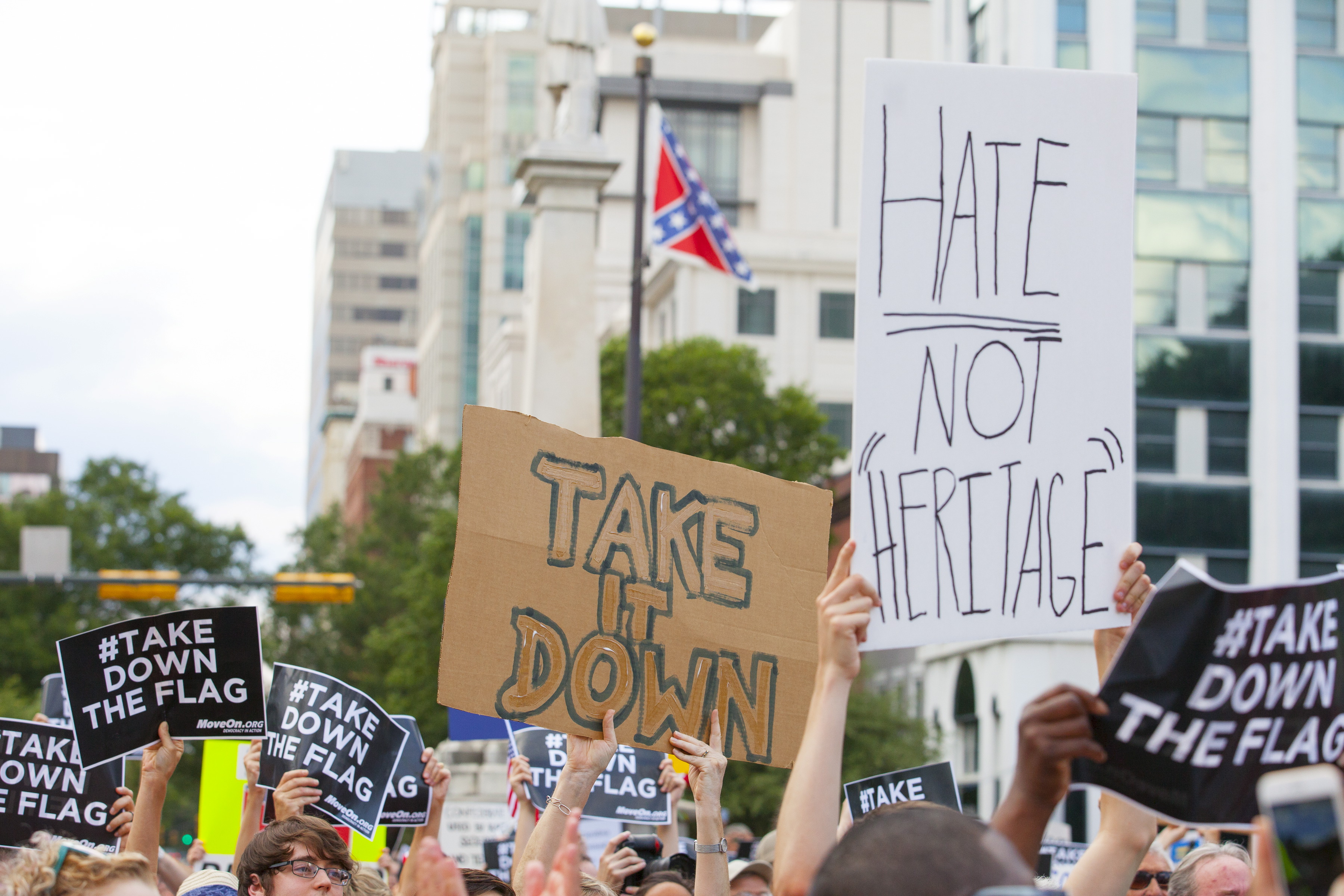 People hold signs during a protest asking for the removal of the confederate battle flag that flies at the South Carolina State House in Columbia